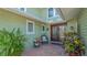 Inviting entrance to the home featuring a brick landing, dark trimmed window, and well maintained landscaping at 1042 N Casey Key Rd, Osprey, FL 34229