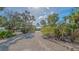 Picturesque home entrance featuring a pebble driveway, a variety of lush tropical landscaping, and a tranquil setting at 1042 N Casey Key Rd, Osprey, FL 34229