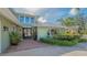 Close up of the exterior featuring a brick paved walkway leading to the front door of the home and mature landscaping at 1042 N Casey Key Rd, Osprey, FL 34229