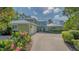 Charming two-story home featuring a lush landscaped front yard, a two-car garage, and a cozy covered porch at 1042 N Casey Key Rd, Osprey, FL 34229