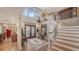 Elegant foyer featuring a grand staircase, a chandelier, and double doors that create a bright entry at 1042 N Casey Key Rd, Osprey, FL 34229