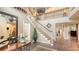 Beautiful foyer featuring a grand staircase, decorative chandelier, and a classic rug adding elegance at 1042 N Casey Key Rd, Osprey, FL 34229