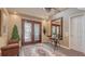 Inviting foyer with glass-paneled double doors, a decorative chandelier, and a classic rug adding elegance at 1042 N Casey Key Rd, Osprey, FL 34229