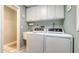 Functional laundry room with a sink, modern washer and dryer, and plenty of overhead cabinet storage at 1042 N Casey Key Rd, Osprey, FL 34229