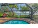 Tranquil screened-in pool area with views of the surrounding lush greenery and waterfront at 1042 N Casey Key Rd, Osprey, FL 34229
