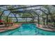 Inviting pool in screened in enclosure with beautiful waterfront and lush landscape views at 1042 N Casey Key Rd, Osprey, FL 34229