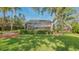 Landscaped backyard featuring a screened-in pool area and lush green lawn at 1042 N Casey Key Rd, Osprey, FL 34229