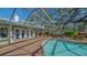 Beautiful pool area featuring screened-in patio, comfortable seating, and lush landscaping at 1042 N Casey Key Rd, Osprey, FL 34229
