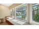 Sitting area featuring a large window, window seat and view of a screened-in pool and waterfront at 1042 N Casey Key Rd, Osprey, FL 34229