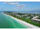Breathtaking aerial view of a coastal community with pristine beaches, luxury condos, and lush landscaping at 1065 Gulf Of Mexico Dr # 103, Longboat Key, FL 34228