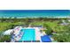 Aerial view of pool and beach access with lush green landscaping and trees at 1065 Gulf Of Mexico Dr # 103, Longboat Key, FL 34228