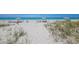 Relax on the sandy beach with lounge chairs and umbrellas under the beautiful blue sky at 1065 Gulf Of Mexico Dr # 103, Longboat Key, FL 34228