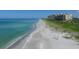 Scenic beach view with white sand, clear blue water, and beachfront condos for a relaxing coastal lifestyle at 1065 Gulf Of Mexico Dr # 103, Longboat Key, FL 34228