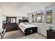 Comfortable bedroom featuring a dark wood dresser and large windows for ample natural light at 1065 Gulf Of Mexico Dr # 103, Longboat Key, FL 34228