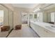 View of the main bathroom featuring a long vanity with double sinks and a bedroom entryway at 1065 Gulf Of Mexico Dr # 103, Longboat Key, FL 34228