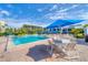 A resort-style pool area with lounge chairs, tables, umbrellas, and lush tropical landscaping at 1065 Gulf Of Mexico Dr # 103, Longboat Key, FL 34228
