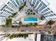 Aerial shot of condo building, street, pool, palm trees, and other green plants at 111 S Pineapple Ave # 716, Sarasota, FL 34236