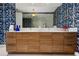 Bathroom featuring a double vanity with blue wallpaper and a glass enclosed shower at 111 S Pineapple Ave # 716, Sarasota, FL 34236