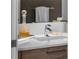 Modern bathroom with a white countertop, stylish faucet, decorative glass bottle, and warm wood-toned cabinetry at 111 S Pineapple Ave # 716, Sarasota, FL 34236
