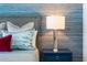 Bedroom with bedside table, modern lamp, and textured blue wallpaper at 111 S Pineapple Ave # 716, Sarasota, FL 34236