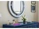 Close-up on blue dresser featuring décor, mirror, and artwork at 111 S Pineapple Ave # 716, Sarasota, FL 34236