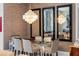 Modern dining room features glass table with seating for six and statement chandelier, with reflective mirrors on the wall at 111 S Pineapple Ave # 716, Sarasota, FL 34236