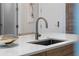 Modern kitchen featuring a stainless steel faucet and sink with a white countertop and decorative bowl at 111 S Pineapple Ave # 716, Sarasota, FL 34236