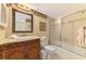 Traditional bathroom with decorative wallpaper, framed mirror, and shower at 1200 Cove Ii Pl # 832, Sarasota, FL 34242