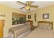 Cozy twin bedroom with ceiling fan and a window view of palm trees at 1200 Cove Ii Pl # 832, Sarasota, FL 34242
