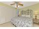 Bright bedroom featuring a decorative headboard, ceiling fan, and closet at 1200 Cove Ii Pl # 832, Sarasota, FL 34242