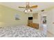 Comfortable bedroom with a tropical-themed ceiling fan, rattan storage chest, and soft lighting at 1200 Cove Ii Pl # 832, Sarasota, FL 34242