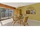 Dining area featuring a glass table with seating for four, a cabinet and access to the outdoor balcony at 1200 Cove Ii Pl # 832, Sarasota, FL 34242