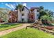 Inviting condo complex with tropical landscaping, wooden staircases, and a brick walkway to the charming building entrance at 1200 Cove Ii Pl # 832, Sarasota, FL 34242
