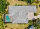 Top-down aerial view of the home, highlighting the roof, screened pool, and surrounding lush landscaping at 12311 Newcastle Pl, Lakewood Ranch, FL 34202