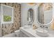 Stylish bathroom with dual sinks, shiplap wall, and illuminated mirrors creating a bright and modern space at 12311 Newcastle Pl, Lakewood Ranch, FL 34202