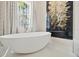 Bright bathroom featuring soaking tub next to a flower art piece under a stylish chandelier at 12311 Newcastle Pl, Lakewood Ranch, FL 34202
