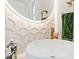 Stylish bathroom featuring a vessel sink, decorative tile, and round mirror with vanity lighting at 12311 Newcastle Pl, Lakewood Ranch, FL 34202