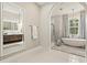 Bright bathroom featuring soaking tub, glass shower, and double vanity with illuminated mirror at 12311 Newcastle Pl, Lakewood Ranch, FL 34202