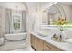 Bright bathroom featuring soaking tub, chandelier, and double vanity with vessel sinks at 12311 Newcastle Pl, Lakewood Ranch, FL 34202