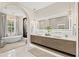 Bright bathroom featuring double vanity, sleek countertops, modern fixtures, and soaking tub with chandelier at 12311 Newcastle Pl, Lakewood Ranch, FL 34202