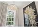 Chandelier and floral decor accent a bright bathroom, with window and soft curtains at 12311 Newcastle Pl, Lakewood Ranch, FL 34202