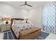 Cozy bedroom with a floral-patterned bedspread, complemented by a woven chest and blue accents for a warm, inviting space at 12311 Newcastle Pl, Lakewood Ranch, FL 34202