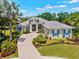 Stunning home featuring lush landscaping, a paver driveway, and charming blue shutters, enhancing its curb appeal at 12311 Newcastle Pl, Lakewood Ranch, FL 34202
