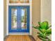 Close-up of the double front doors with glass panels, a woven doormat, and potted plant on the side at 12311 Newcastle Pl, Lakewood Ranch, FL 34202