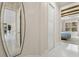 Bright hallway with white flooring, large mirror and a bedroom in the background at 12311 Newcastle Pl, Lakewood Ranch, FL 34202