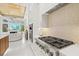 Modern kitchen features a pro-grade cooktop and range hood, and a view into the naturally lit living area at 12311 Newcastle Pl, Lakewood Ranch, FL 34202
