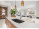 Kitchen island boasts quartz counters and custom wooden cabinets, enhancing entertaining with pendant lights at 12311 Newcastle Pl, Lakewood Ranch, FL 34202