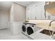 Well-organized laundry room with modern washer, dryer, storage cabinets, and countertop space at 12311 Newcastle Pl, Lakewood Ranch, FL 34202
