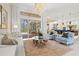 Bright living room open to the kitchen featuring hardwood floors, a modern chandelier, and access to the patio at 12311 Newcastle Pl, Lakewood Ranch, FL 34202
