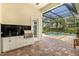 Outdoor kitchen on brick patio includes black granite counters, stainless steel grill, and screened-in pool at 12311 Newcastle Pl, Lakewood Ranch, FL 34202